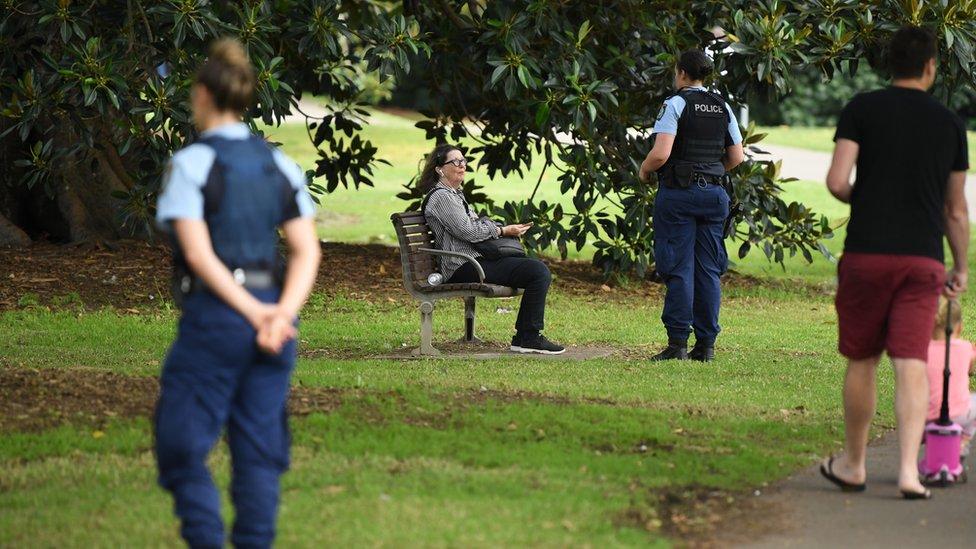 Австралийская полиция в парке Сиднея подходит к посетителям и просит их двигаться дальше
