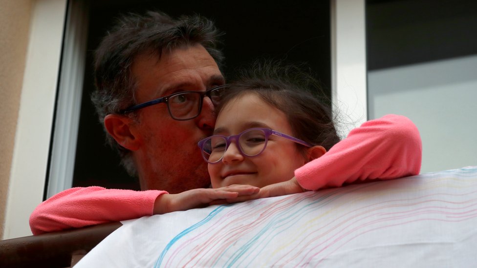 Мужчина целует свою дочь после аплодисментов в поддержку медицинских работников