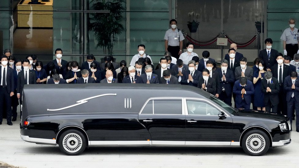 A hearse carrying the body of former Japanese Prime Minister Shinzo Abe, makes a brief visit to the Prime Minister's Office, as Japan's Prime Minister Fumio Kishida, officials and employees offer prayers, in Tokyo, Japan July 12, 2022, in this photo taken by Kyodo. Mandatory credit