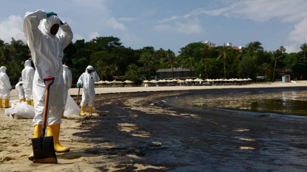 Radnici u zaštitnom odelu uklanjaju naftu sa plaže