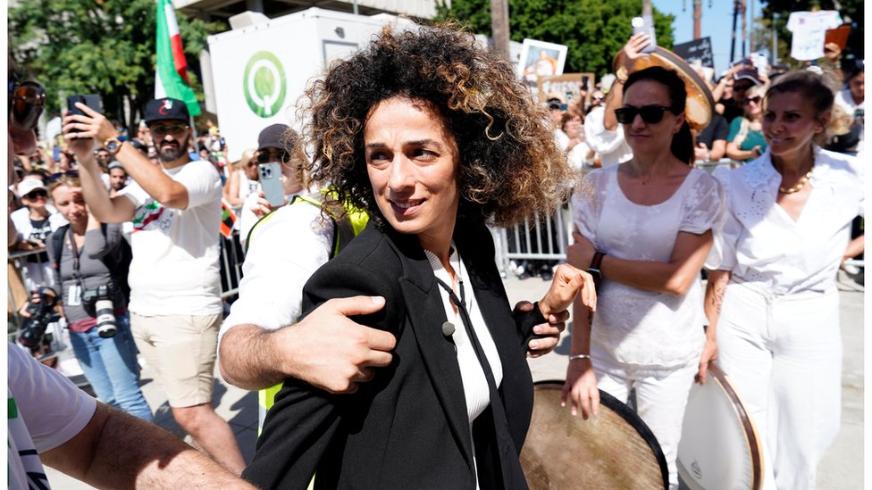 Masih Alinejad is escorted by security at a rally in support of Iranian women and against the death of Mahsa Amini outside City Hall in Los Angeles, California on 1 October, 2022
