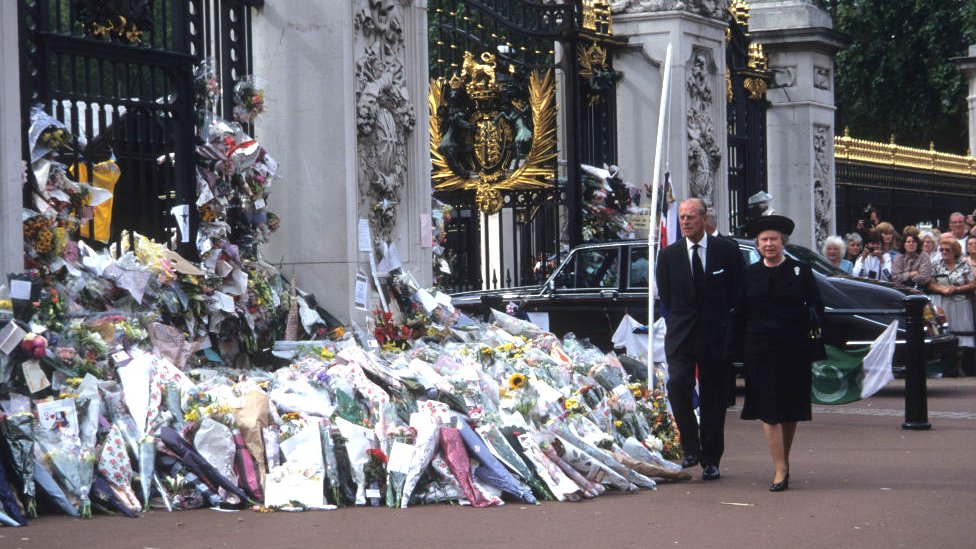 La reina y el príncipe Felipe frente a las flores depositadas en Buckingham tras la muerte de Lady Di.