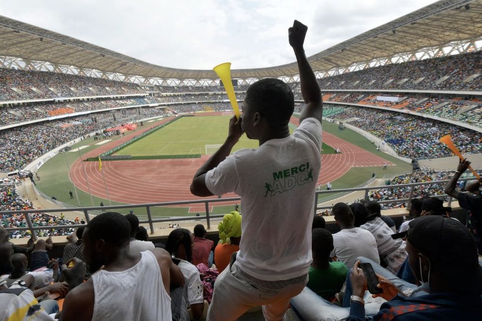 A man blows a vuvuzela during the inauguration ceremony of Ivory Coast's new 60,000-seat Olympic stadium, built with the help of China, in Ebimpe, outside Abidjan, on October 3, 2020 ahead of 2023 Africa Cup of Nations.
