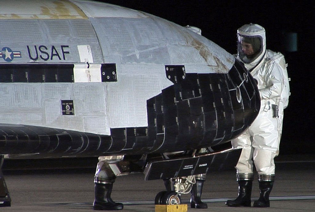 Técnicos en trajes protectores examinan el X-37B