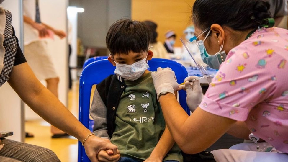 A teenage Thai boy holds his mother's hand while receiving his first dose of Pfizer's Covid-19 vaccine at Vachira Hospital on September 21, 2021 in Bangkok, Thailand.