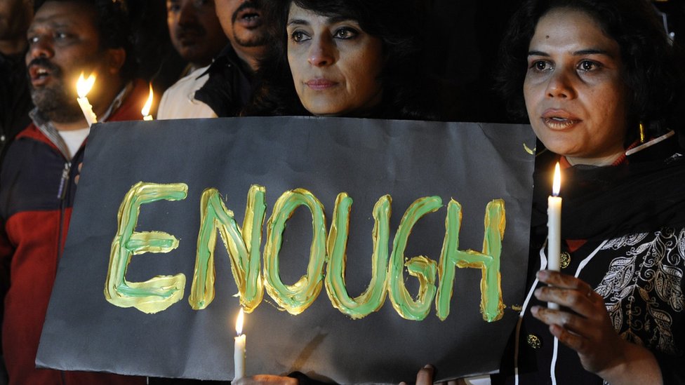 Пакистанские журналисты держат табличку со словом «ДОСТАТОЧНО» и зажигают свечи, чтобы помолиться за жертв, погибших в результате нападения на армейскую школу в Пешаваре, во время мемориальной церемонии в Исламабаде, Пакистан, 16 декабря 2014 г.