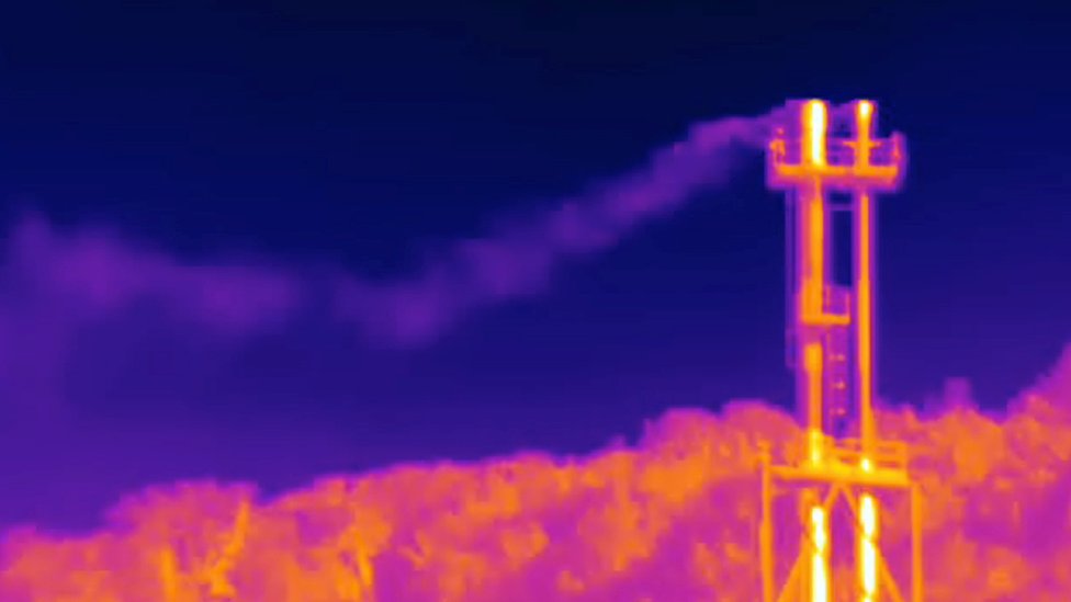 An infrared camera captures what appears to be methane escaping from a natural gas facility