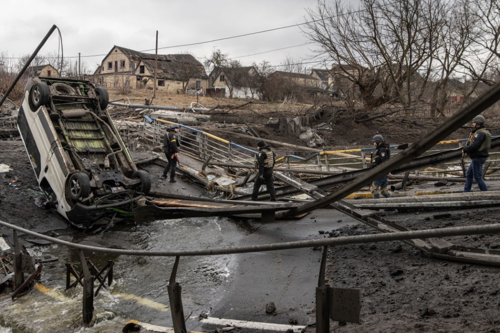 Esta foto del 3 de marzo muestra a soldados ucranianos cruzando un puente destruido en combates en Bucha e Irpín.