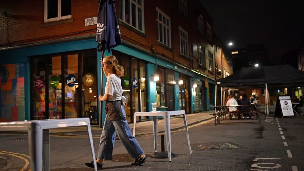 Женщина собирает вещи в баре на открытом воздухе в Манчестере