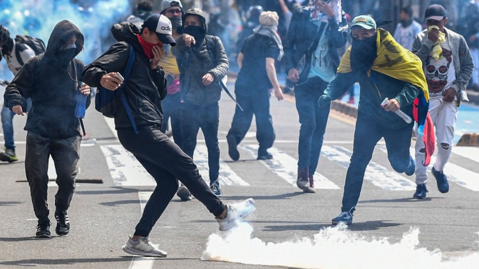 Demonstrators confront riot police during a protest against the government in Bogota
