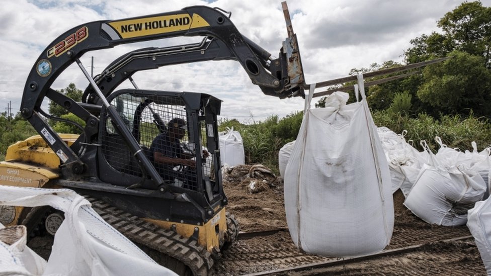 Crews работает над защитой территорий от затопления мешками с песком в Бель-Шассе, штат Луизиана