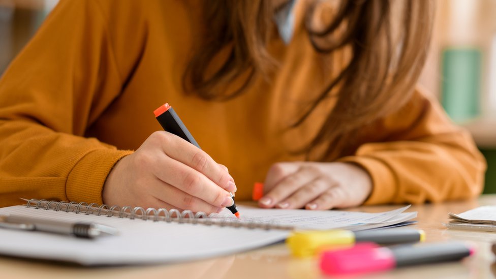 Niña resaltando notas