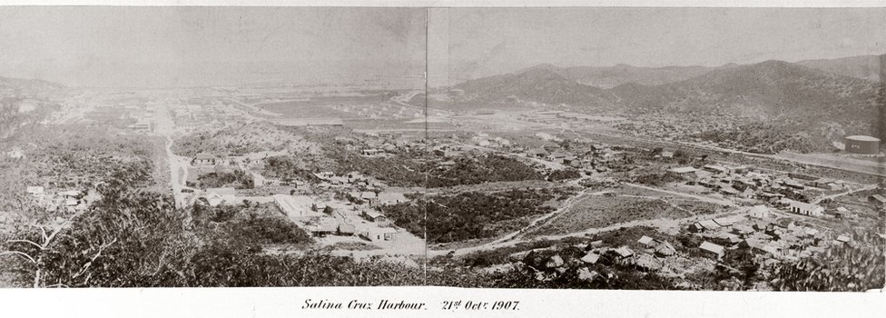 Entre 1899 y 1907 la firma británcia S. Pearson & Co construyó una línea ferroviaria que cruzaba el Istmo de Tehuantepec y unía así el Golfo de México y la costa del Pacífico. Salina Cruz era uno de sus extremos. Fotografía panorámica de Salina Cruz, un puerto del Istmo de Tehuantepec, en el Atlántico, en México. 1907.