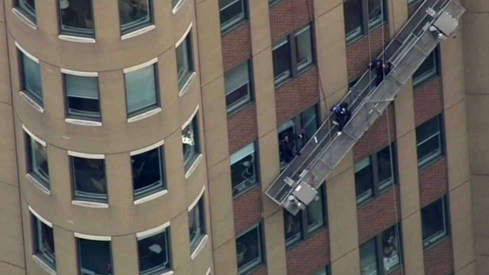 Window washers' scaffold dangles against building