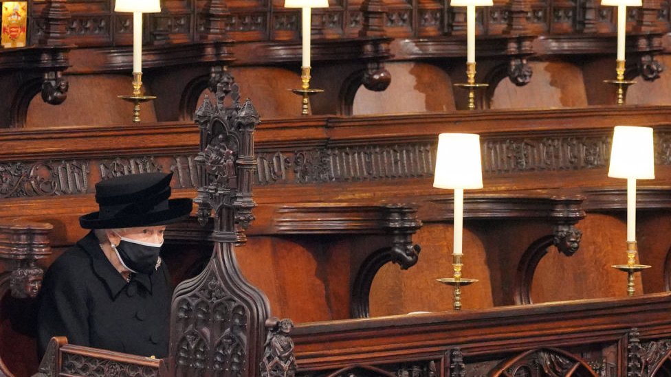 La reina Isabel II sentada en el interior de la capilla de San Jorge.