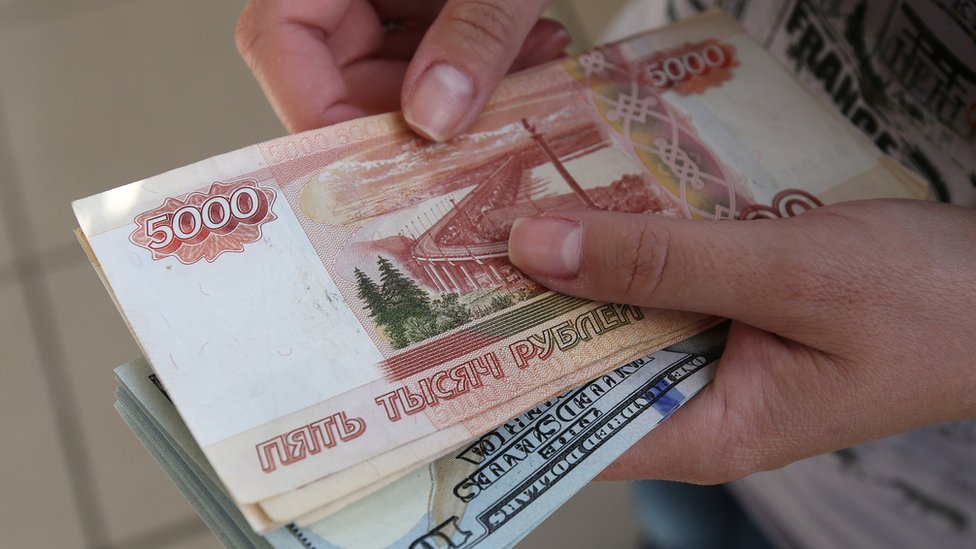 Rusya'da bir döviz bürosu çalışanının elinde tuttuğu 5000 rublelik banknotlar.
