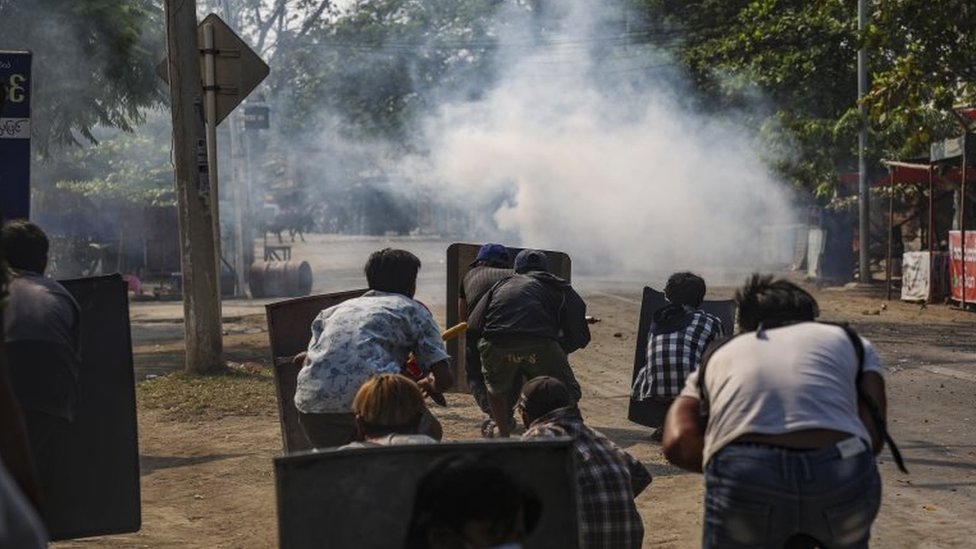 Protesters react after police fire teargas in Mandalay, Myanmar. Photo: 13 March 2021