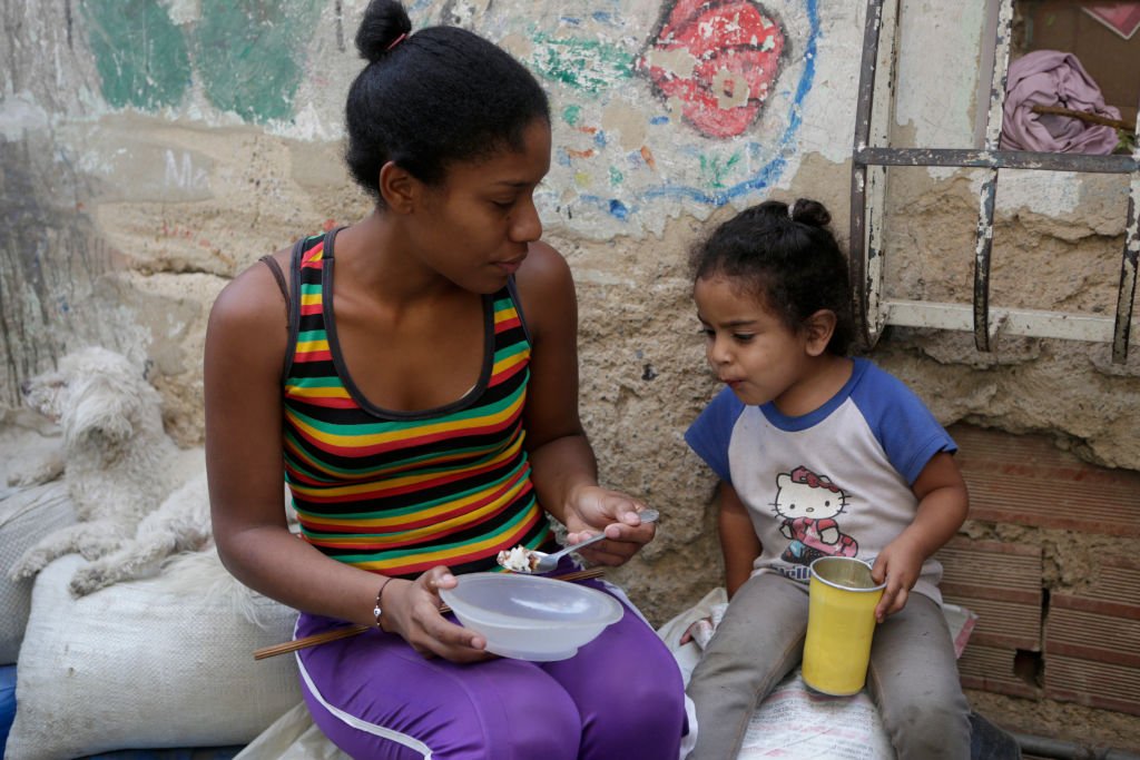 Una madre venezolana le da un poco de comida a su hija