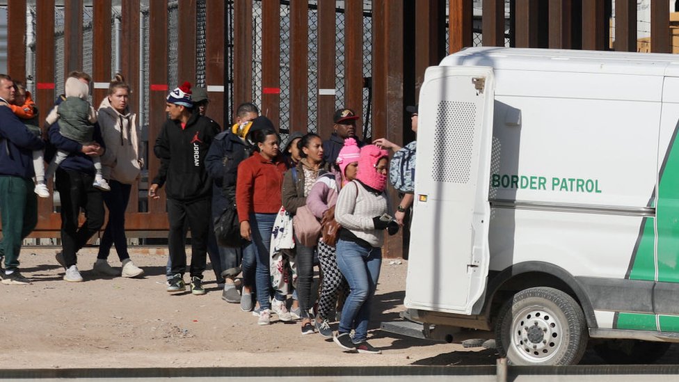 Migrantes subiendo a la furgoneta de un policía de la frontera en Estados Unidos