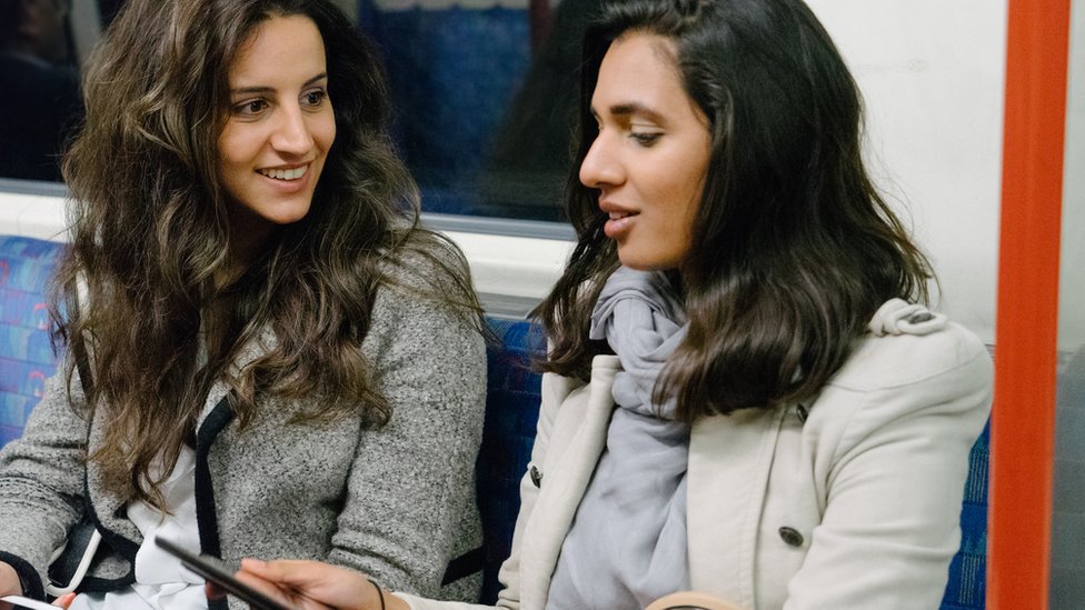 Two women talking on the tube