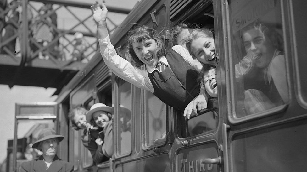 19 мая 1940 года: группа школьников машет рукой на прощание из окна поезда в день, когда десять тысяч детей были эвакуированы из Лондона в Монмут и Гламорган