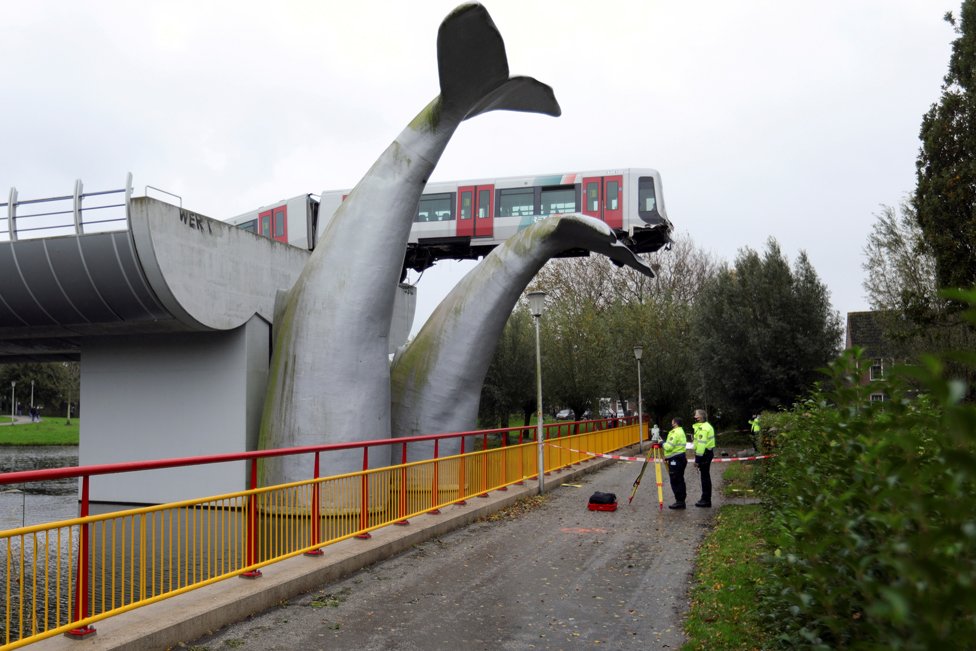 A metro train rests precariously on an art installation of a whale in Spijkenisse, near Rotterdam, Netherlands, 2 November 2020