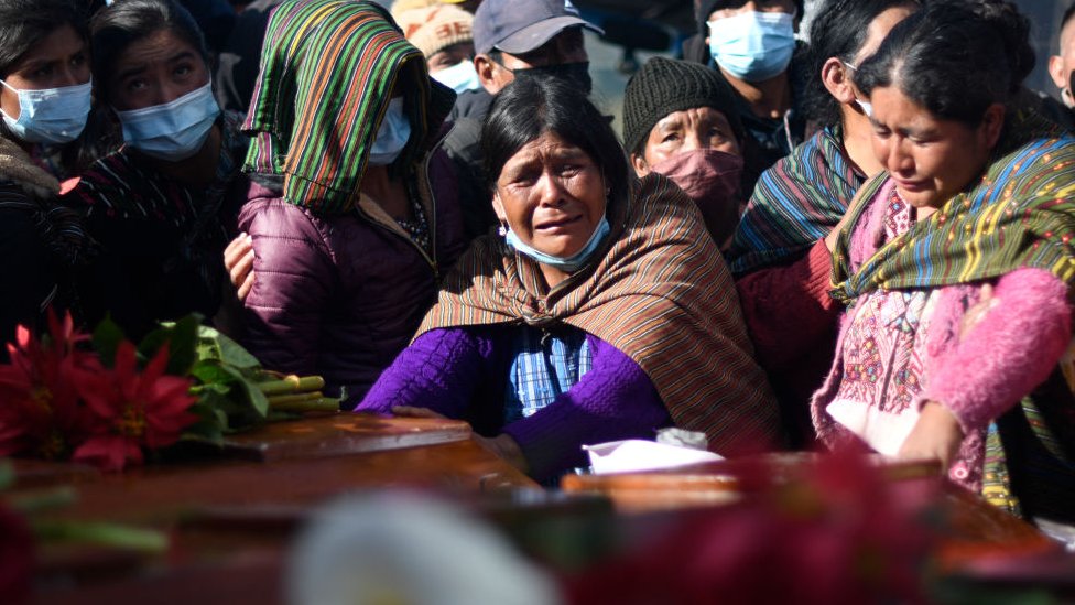 Una mujer llora ante un ataúd de una de las víctimas