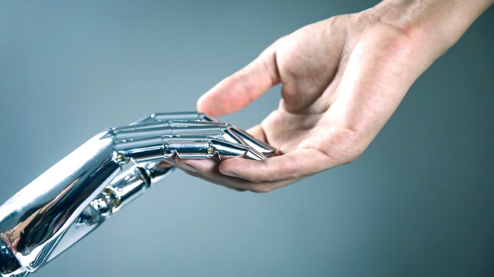 Imagen de una mano robótica y una humana uniéndose.