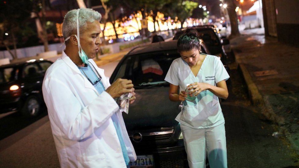 Врачи Карлос Мартинес и Мария Мартинес перекусывают, ожидая очереди за топливом на заправке во время общенационального карантина из-за вспышки коронавирусной болезни (COVID-19) в Каракасе, Венесуэла, 7 апреля 2020 г.