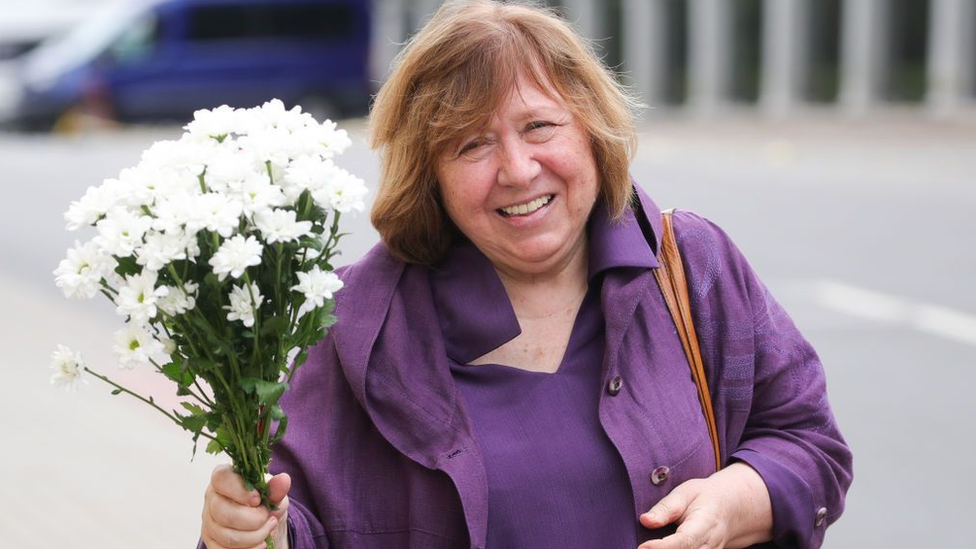 Nobel prize laureate, Belarusian writer and journalist Svetlana Alexievich, summoned for questioning over the formation of the Coordination Council of Belarus, holds flowers outside the offices of the Belarusian Investigative Committee.