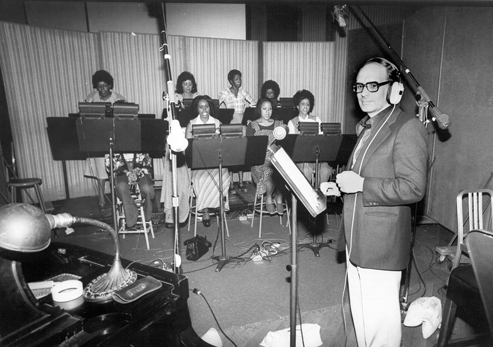 Morricone with singers in a recording studio