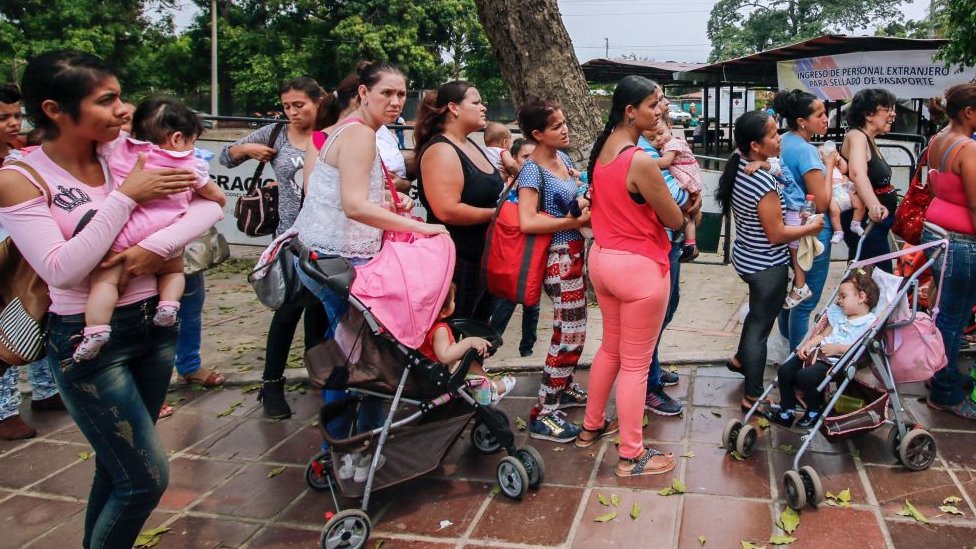 Mujeres cargan a sus hijos en un centro de vacunación de Colombia