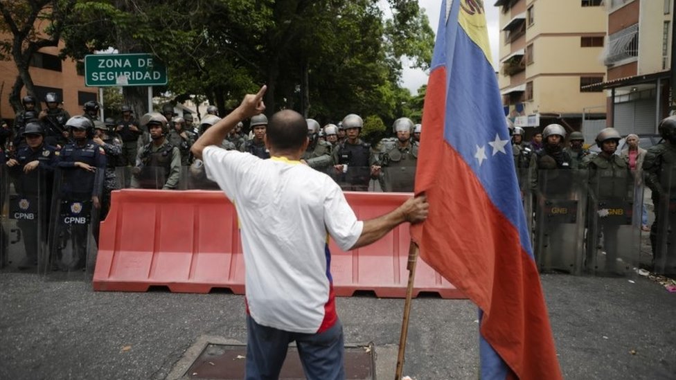 Manifestante opositor a Maduro frente a la Policía Nacional Bolivariana