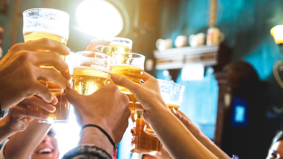 Mãos brindando com copos de cerveja