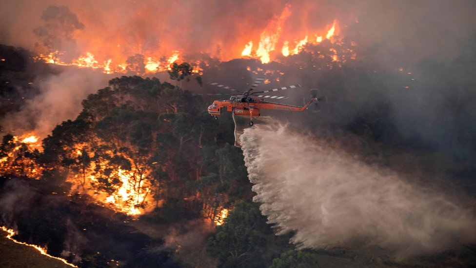 Вертолет роняет воду на лесной пожар
