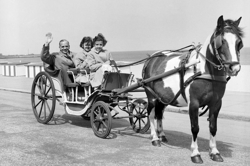 мужчина с двумя девушками в конном экипаже