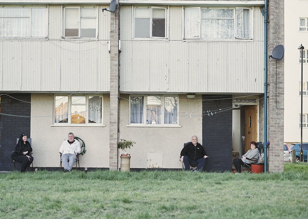People sitting outside their homes