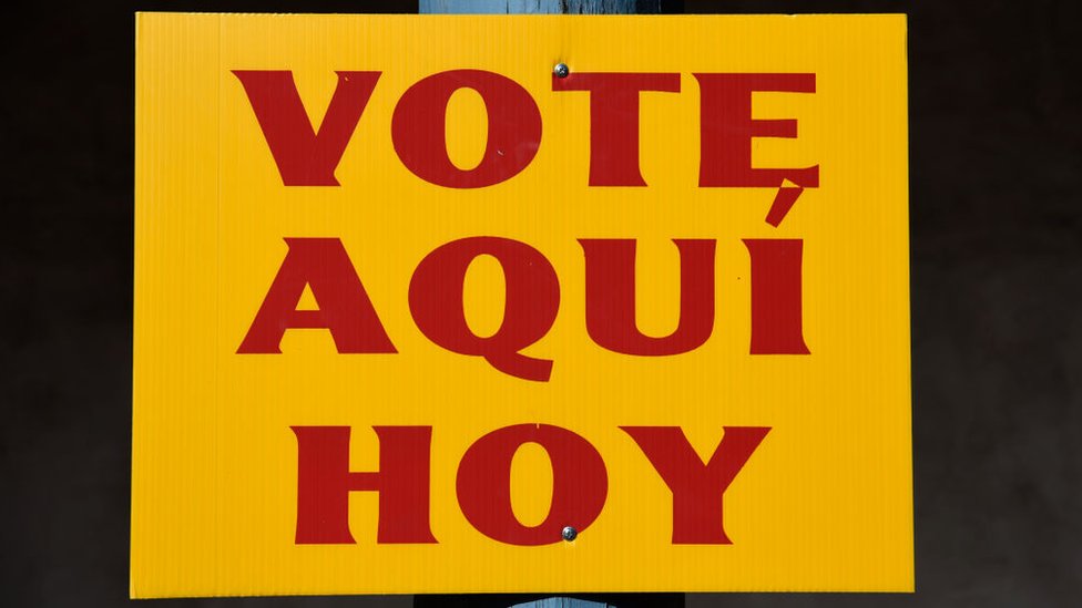 Cartel en español que dice "Vote aquí hoy"