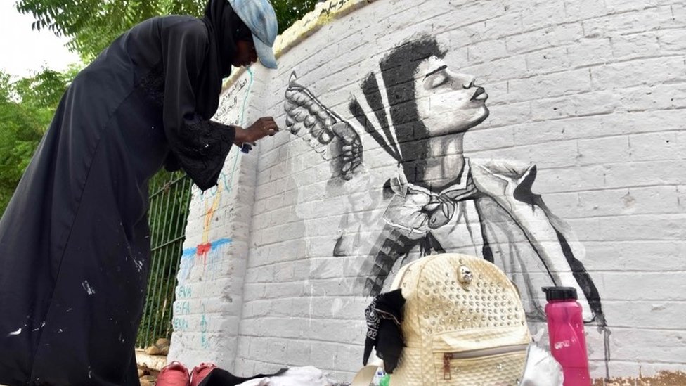 Суданский художник рисует фреску на стене в столице страны Хартуме 22 августа 2019 года