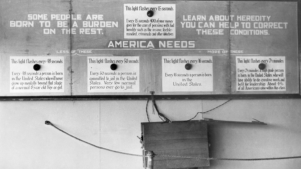 Propaganda de AES: "Hay gente que nace para ser una carga para el resto" (izq.). Las luces en las cajas se prenden a diferentes intervalos: 15 segundos, para indicar cada vez que se gastan US$100 en gente "defectuosa"; 48 segundos, cada vez que nace en EE.UU. con deficiencia mental; 50 segundos, alguien es encarcelado y "poca gente normal va a la cárcel". EE.UU. necesita menos de esos, dice. A la derecha hay dos luces que indican de cuales si necesita. Propaganda de AES