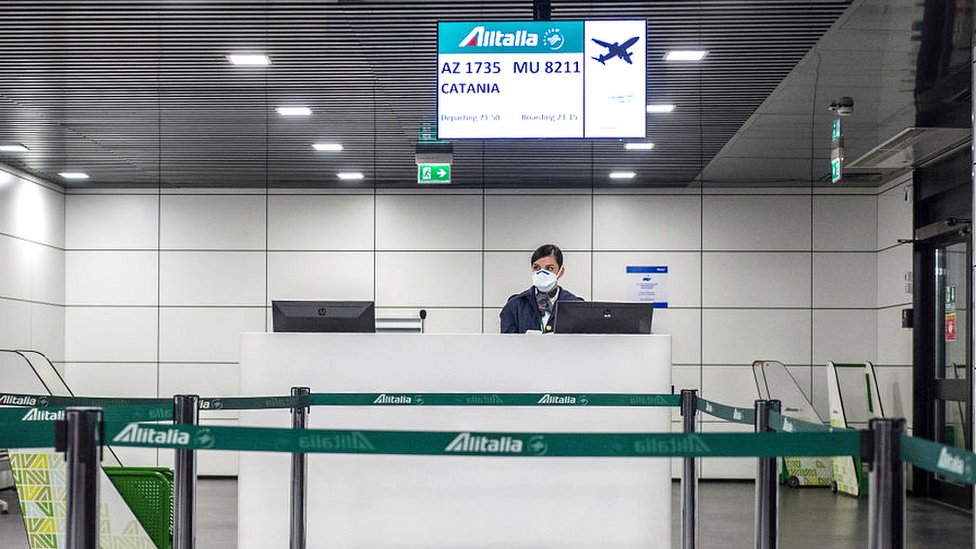 airport worker in italy wearing a mask