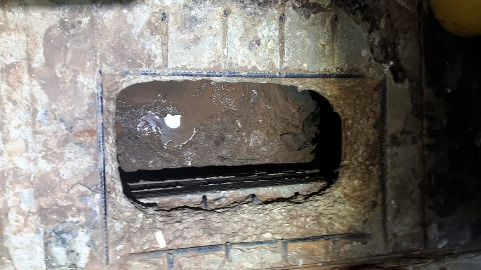 Hueco debajo del piso del baño de la celda que estaba conectado a una cavidad existente debajo de la prisión.