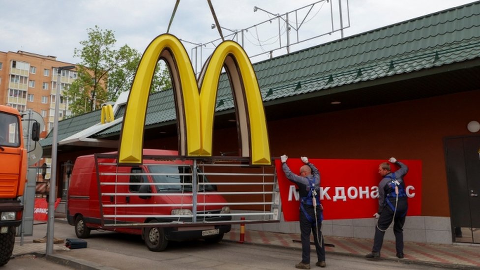 Workers remove the McDonald's logo in a Russian restaurant