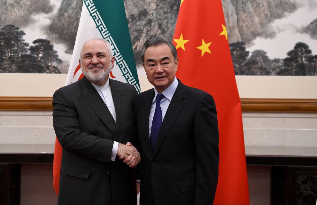 وزير الخارجية الصيني وانغ يي يصافح نظيره الإيراني محمد جواد ظريف خلال لقائهما في بكين، 31 ديسمبر/كانون أول 2019
