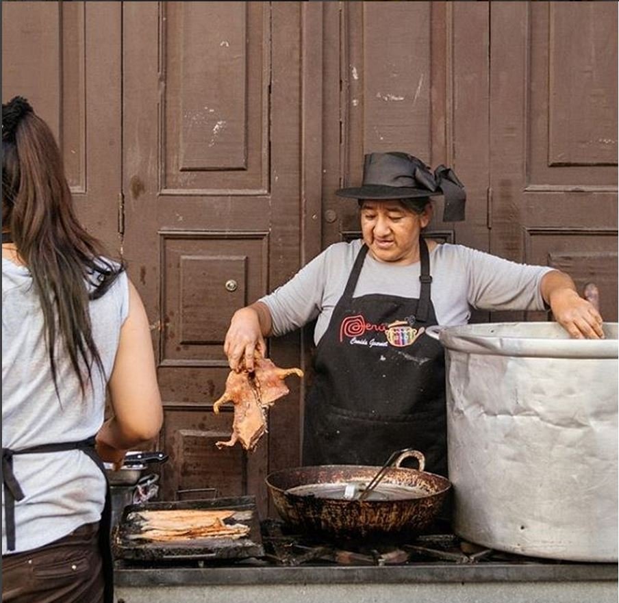 Mujer prepara un cuy y lo saca de una olla Mujer prepara un cuy y lo saca de una olla