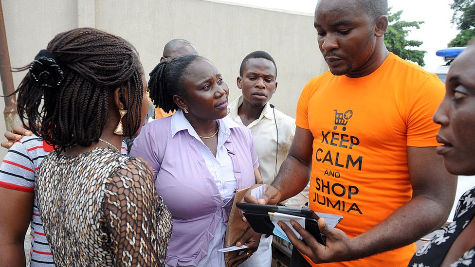 Продавец из Jumia пытается продать товары прохожим в Лагосе 12 июня 2013 года.