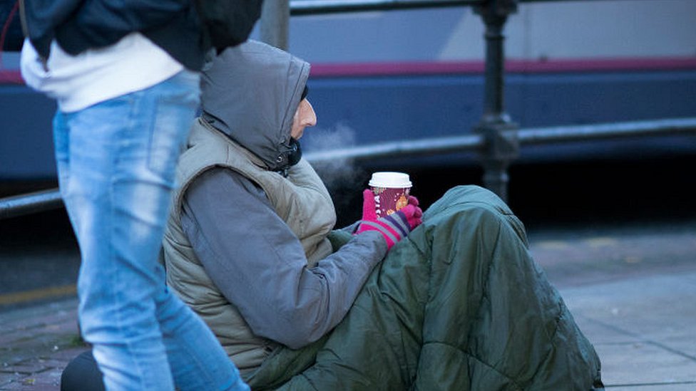 Бездомный с горячим напитком в холодную погоду