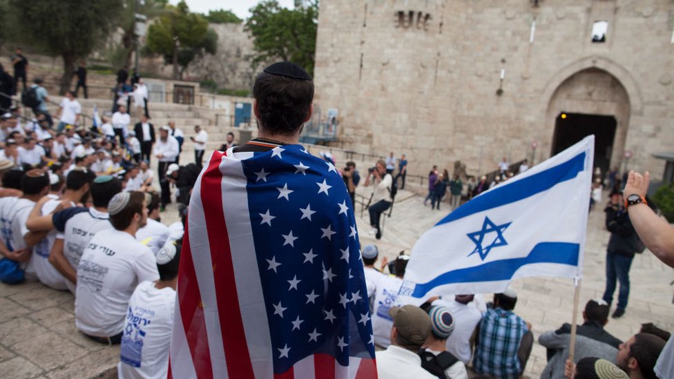Jóvenes con banderas de EE.UU. e Israel en Jerusalén.