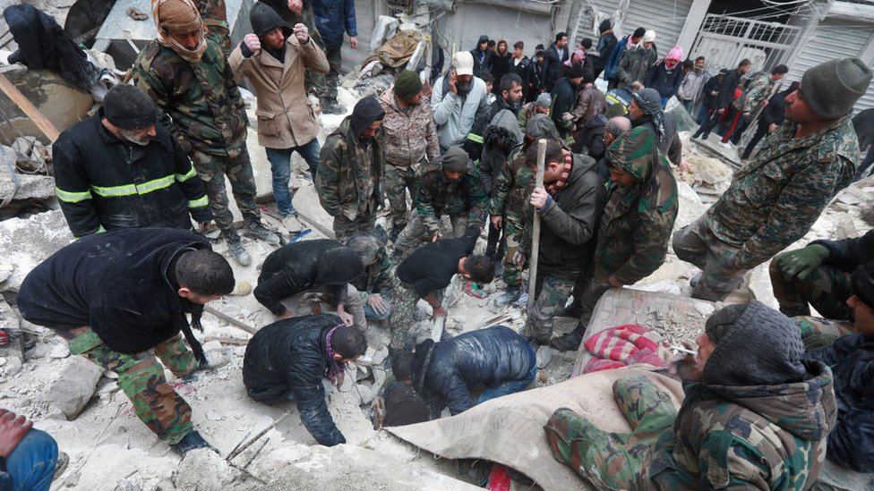 Equipos de rescate sirios buscan víctimas y supervivientes entre los escombros de un edificio derrumbado en la ciudad de Alepo tras un mortífero terremoto el 6 de febrero de 2023.