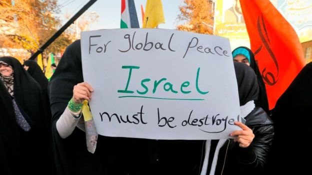 Manifestantes con una pancarta que dice: "Para la paz global, Israel debe ser destruida"